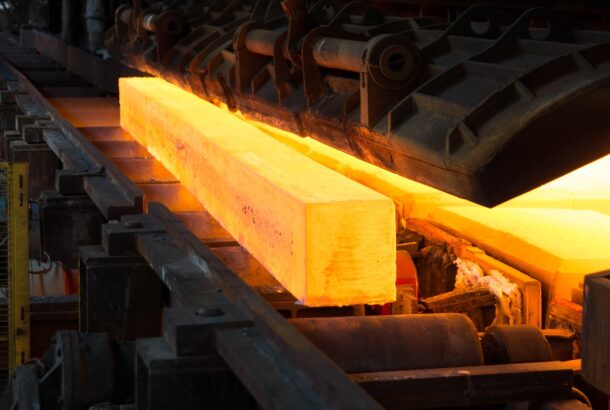 a red hot steel rod on a conveyer belt in a steel factory